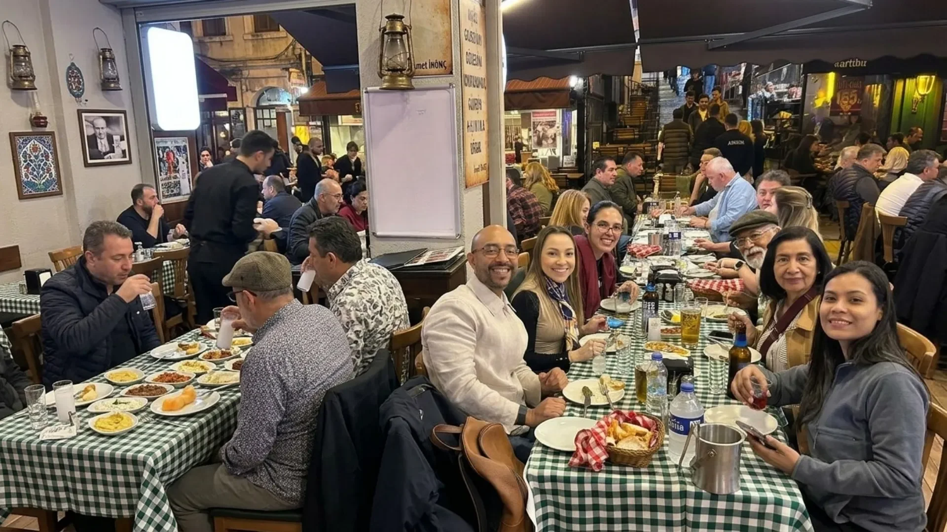 Authentic Turkish meyhane experience during a private night tour Istanbul, featuring a traditional rakı table with appetizers and local friends in a historic setting.