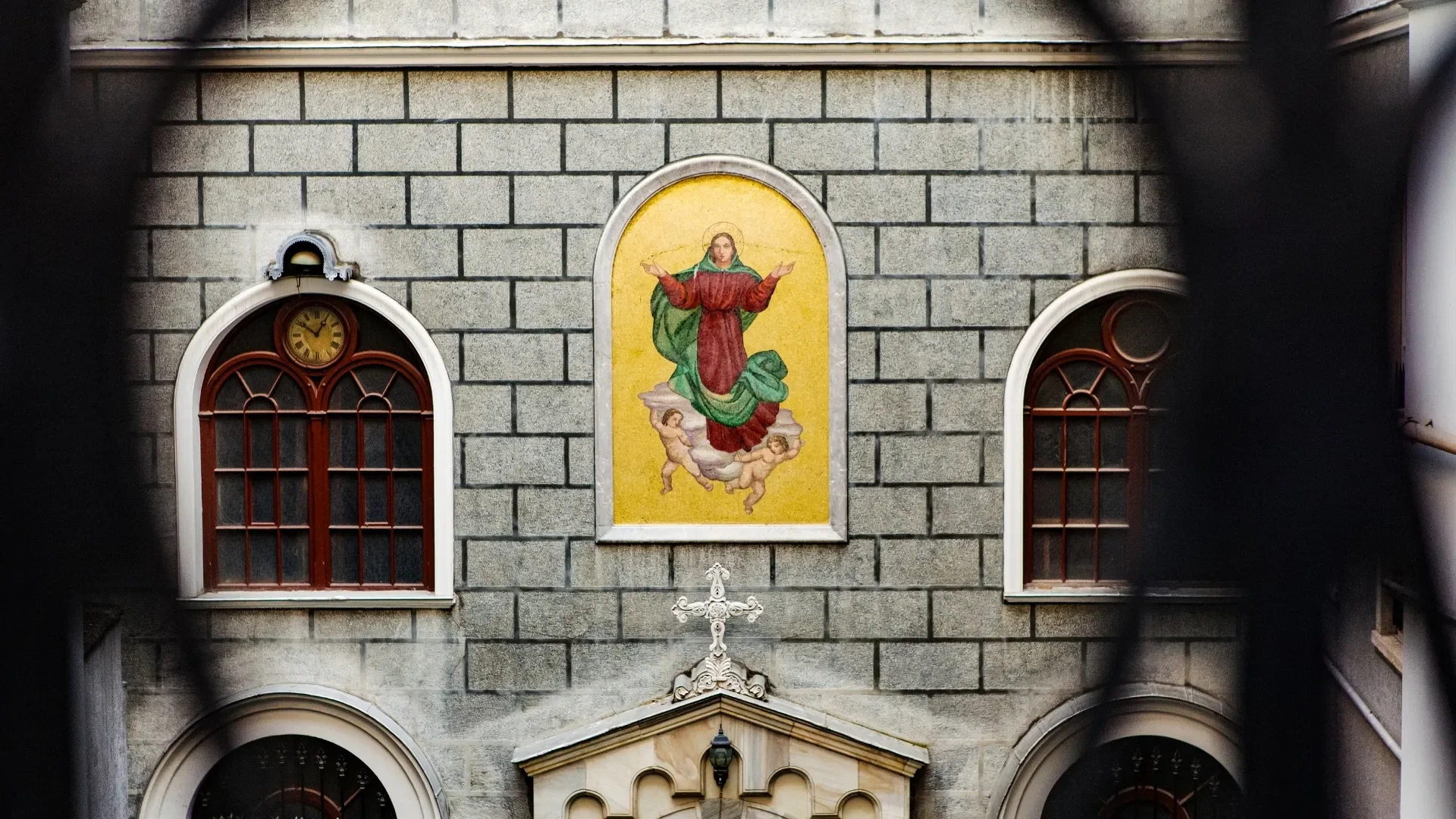 Religious mosaics and stone details on the exterior of a historic Istanbul church.
